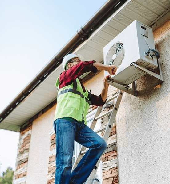 Technician on ladder repairing outdoor AC unit
