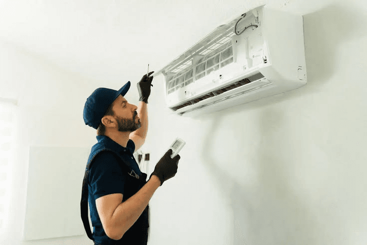 Technician servicing indoor split AC unit