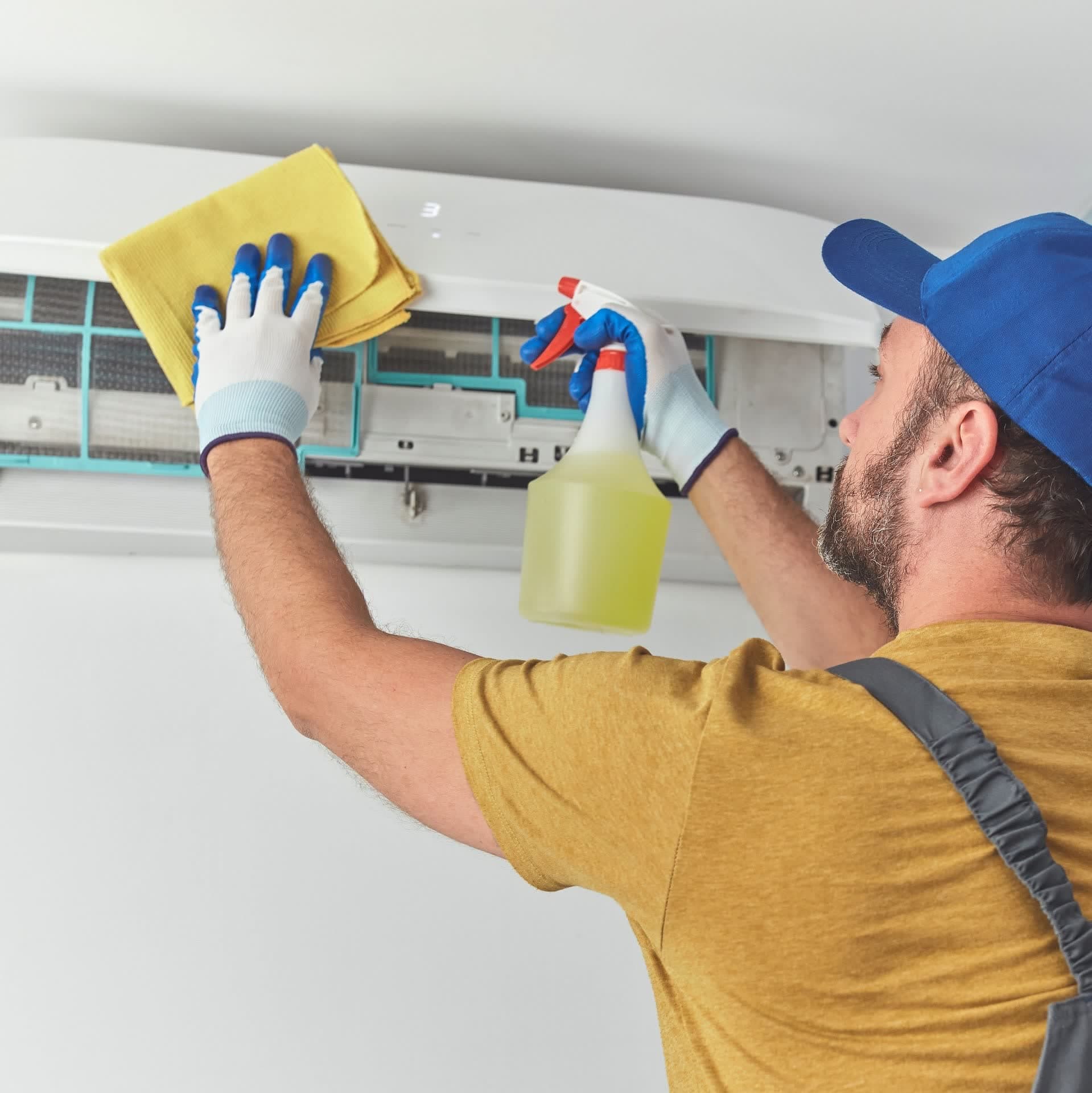 Technician cleaning split AC indoor unit